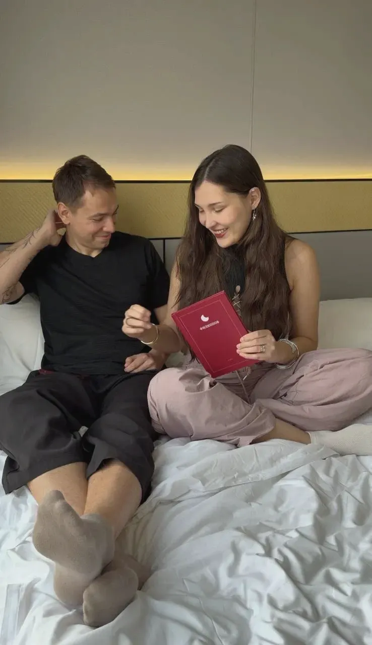 Пара на кровати с красной книгой LunoBooks